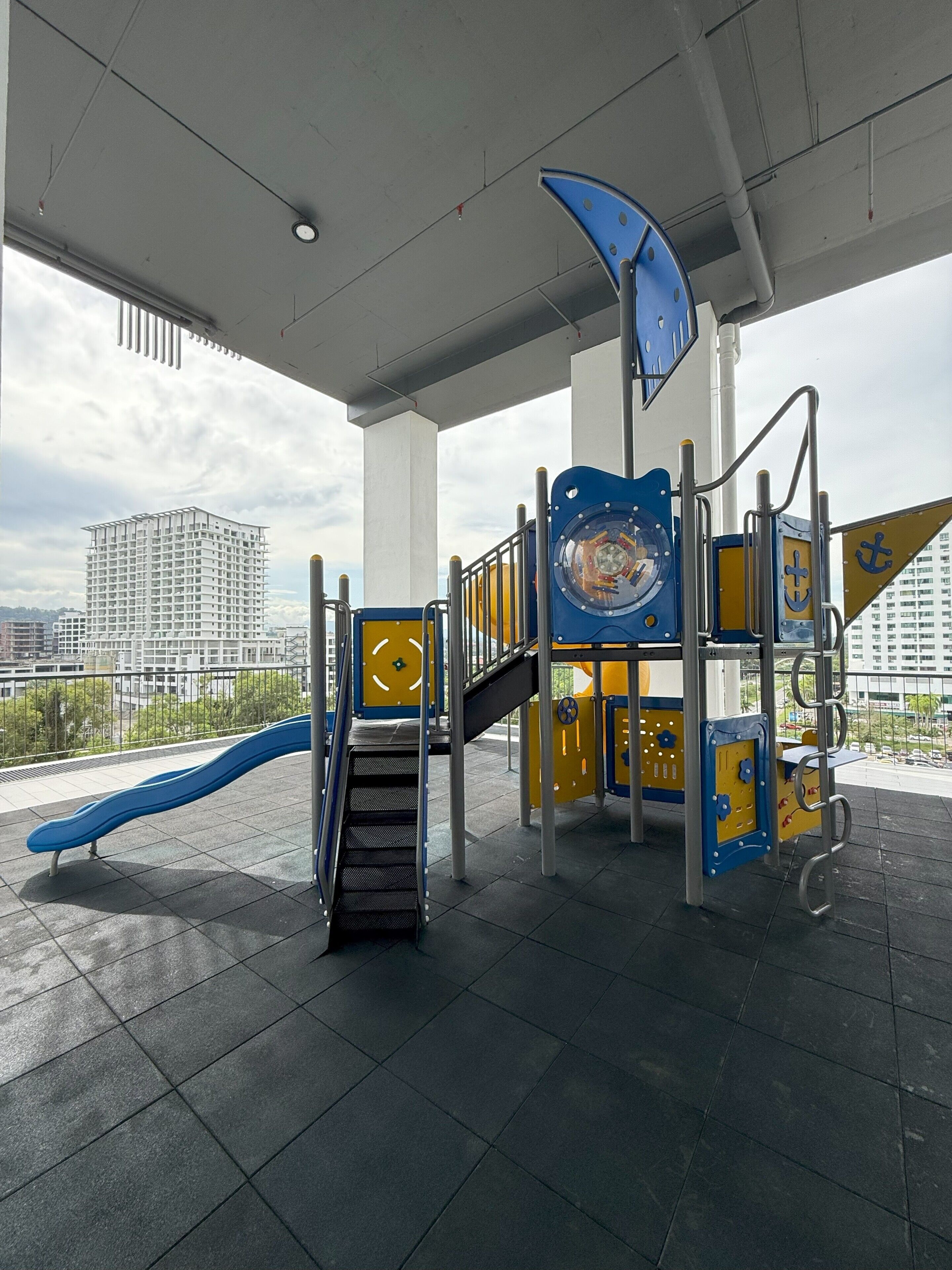 A playground with a slide, climbing structure, and a circular play area.