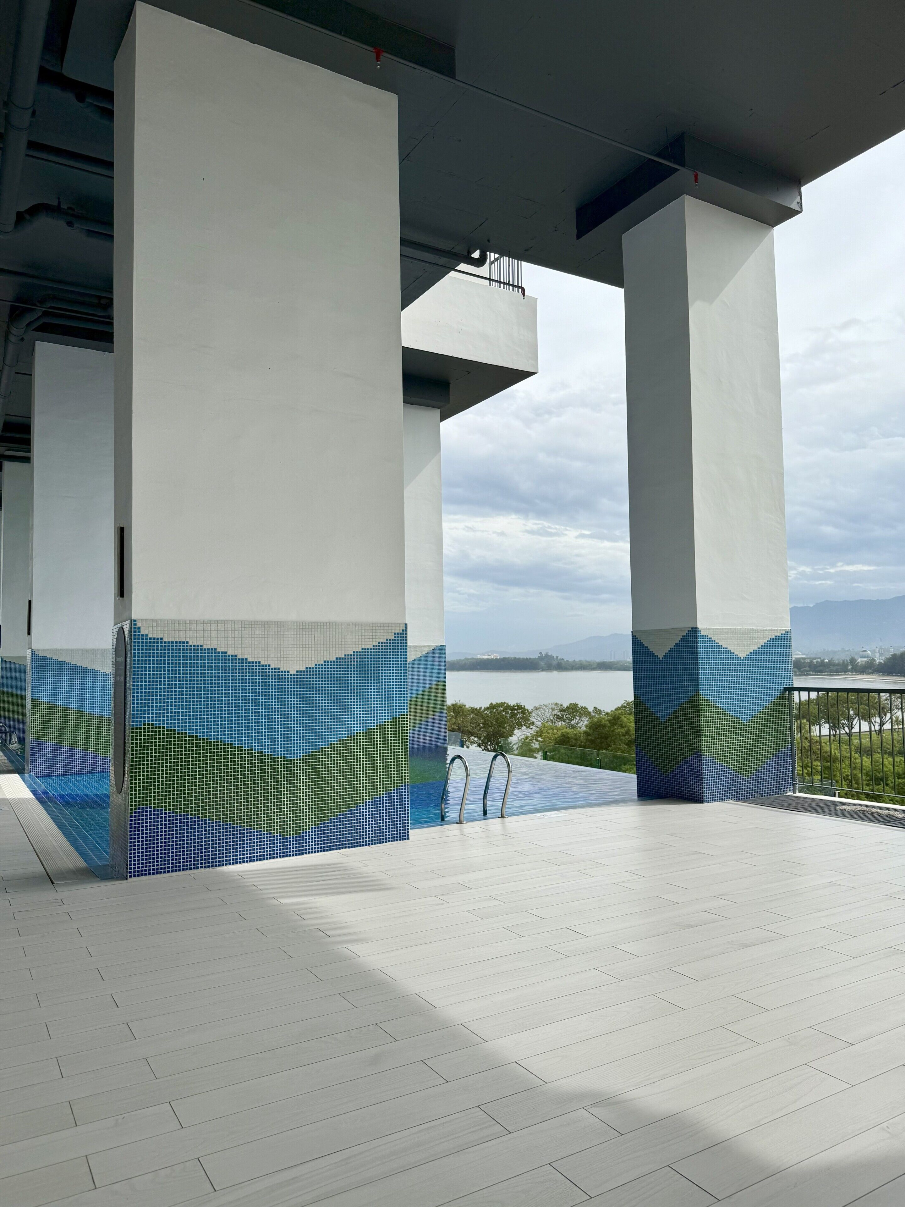 A modern architectural structure with large columns and a tiled floor.