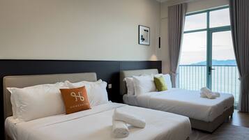 A hotel room with two beds, a large window with a view, and a framed picture on the wall.