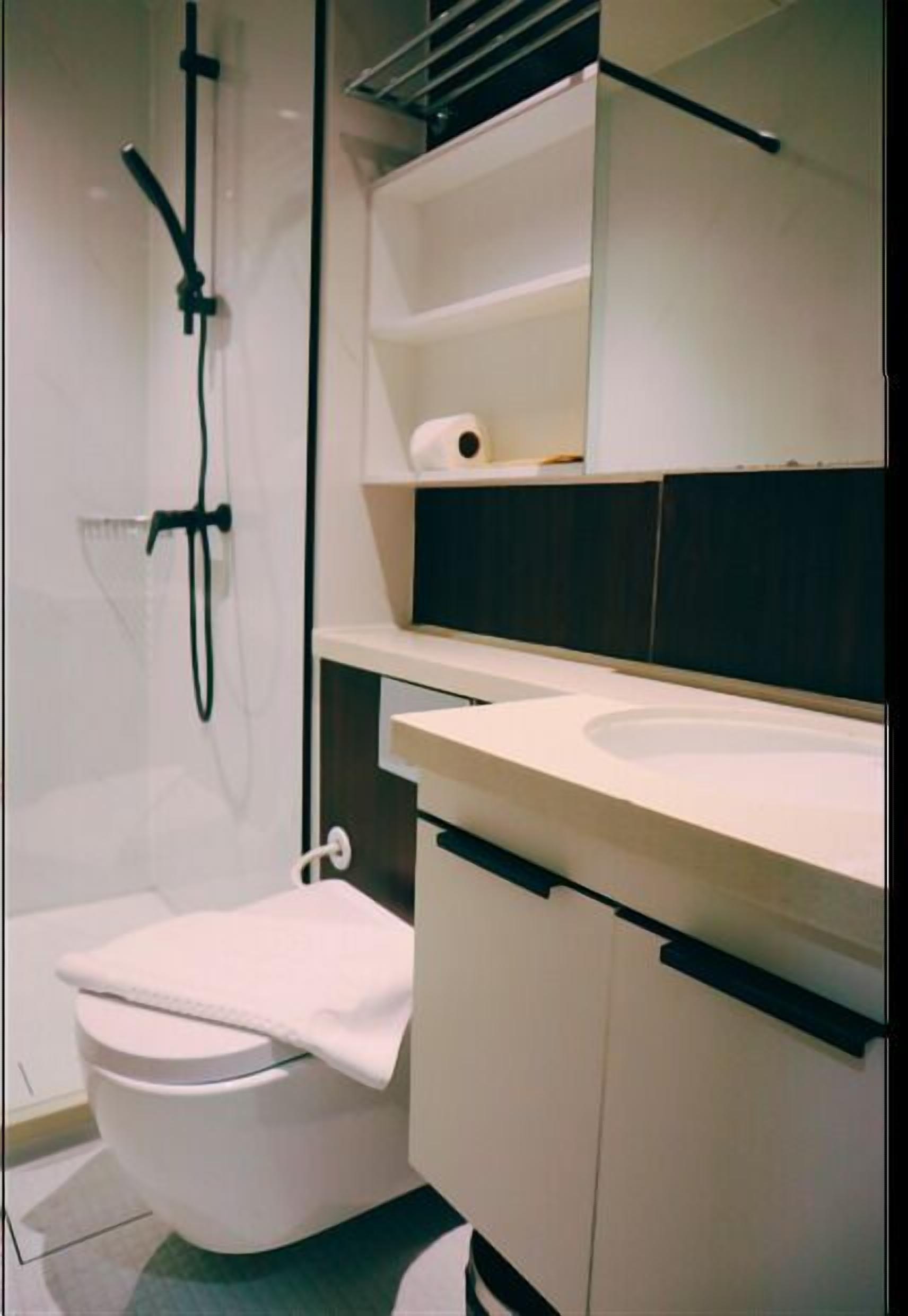 Une salle de bain moderne équipée de toilettes, d’une douche et d’un lavabo.