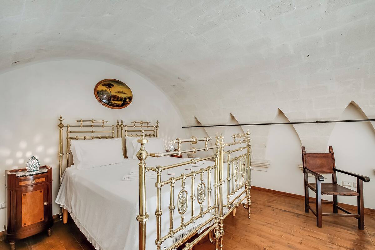 A room with a bed, a chair, and a small table.