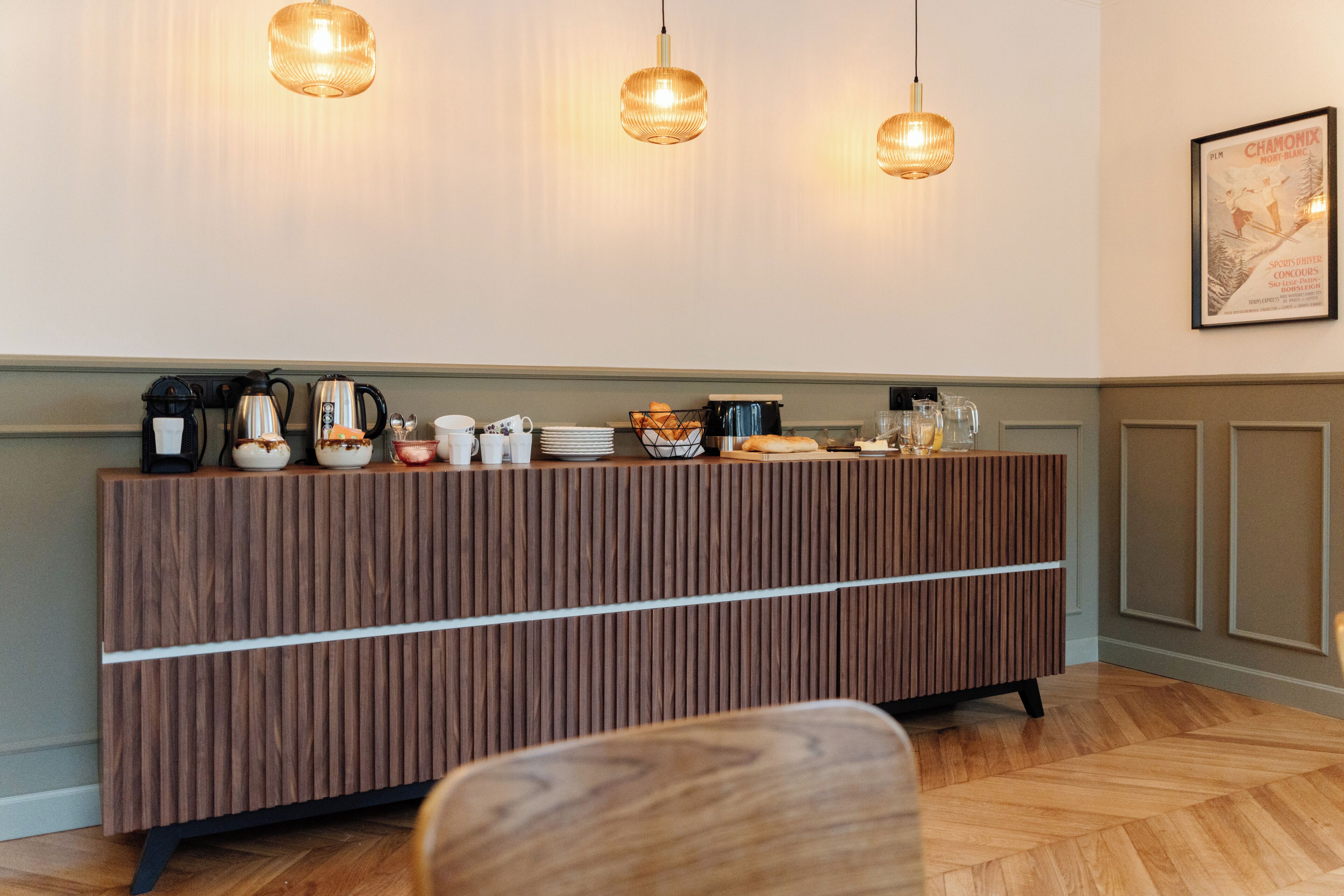A reception area with a wooden counter, coffee machines, and a framed poster on the wall.