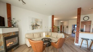A living room with a fireplace, a sofa, two armchairs, and a coffee table. - Big Beach Escape – Oceanview•Walk to Trail•Fireplace (Ucluelet)