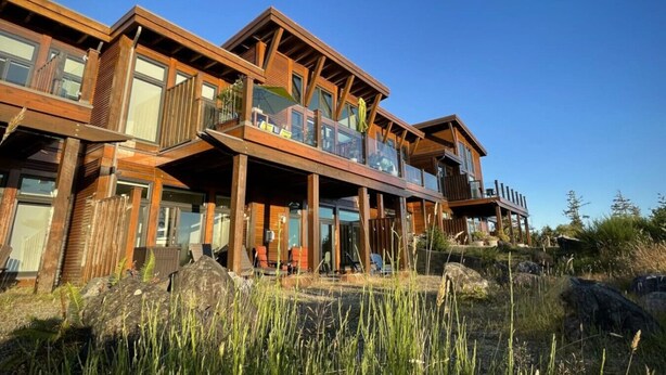 A modern wooden house with multiple balconies, large windows, and a view of the surrounding landscape. - Big Beach Escape – Oceanview•Walk to Trail•Fireplace (Ucluelet)