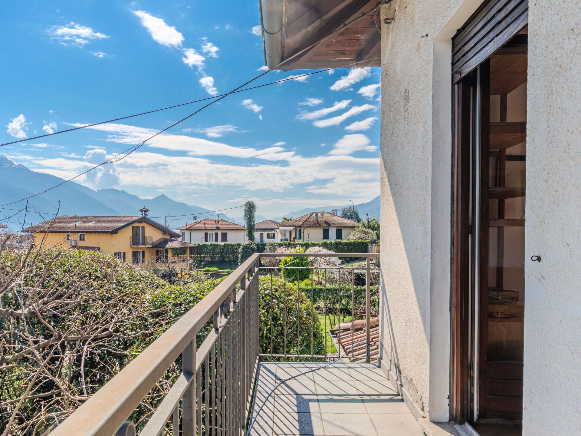 Uma varanda com vista para casas e montanhas.