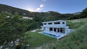 A modern two-story house with a swimming pool, surrounded by lush greenery and hills. - Sensation Ventoux, villa in Baronnies provençales (Beauvoisin)