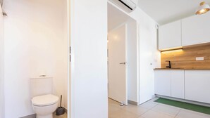 Una cocina moderna con armarios blancos, encimera de madera y un tapete verde en el suelo.