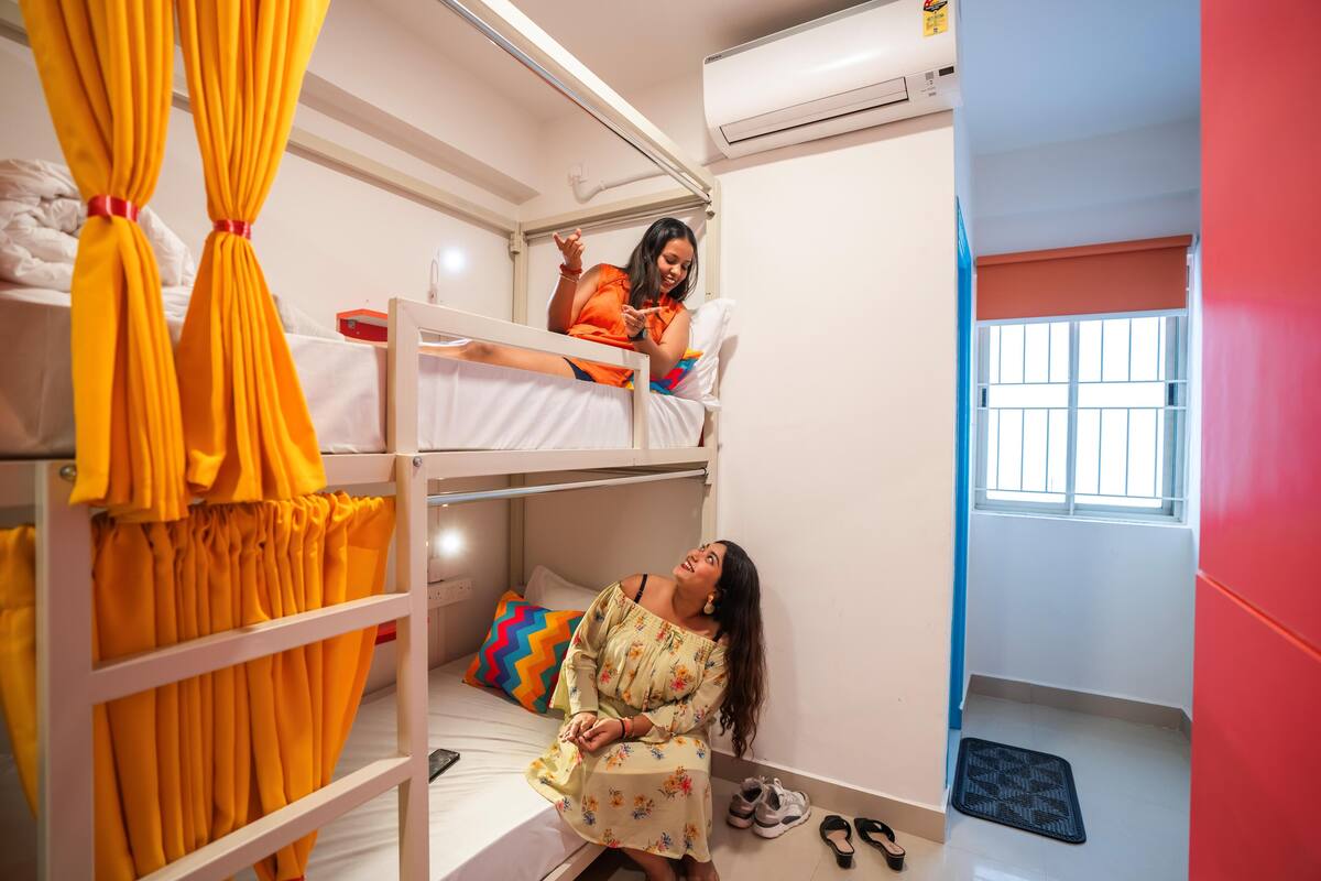Camera con letto a castello, una finestra e un paio di scarpe sul pavimento.