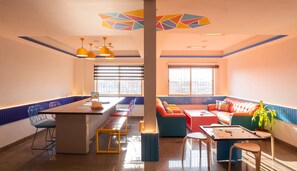A modern interior with a dining area, a sofa set, and a foosball table. - goSTOPS Bengaluru HSR Silk Board (Bengaluru)