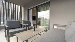 A balcony with grey sofas, a table, and two chairs. - Apartment Tissa (Pula)