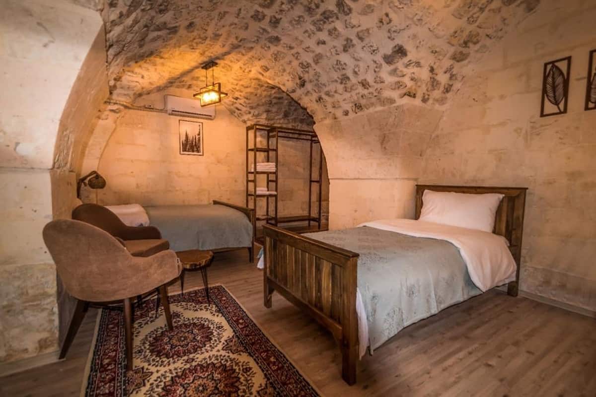 Une chambre mansardée chaleureuse, avec un lit en bois rustique, un petit bureau et une chaise.