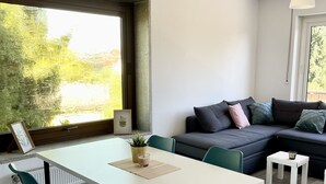 A modern living space with a dining area, a sofa, and a view of greenery outside. - Apartment with balcony, Stein near Nuremberg (Stein)