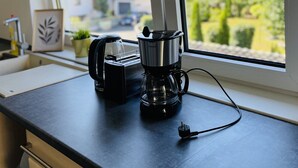 A kitchen counter with a coffee maker, a toaster, and a window with blinds. - Apartment with balcony, Stein near Nuremberg (Stein)