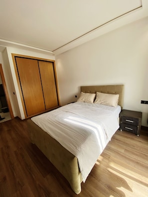 Cozy retreat with a large bed, nightstand, and wardrobe.