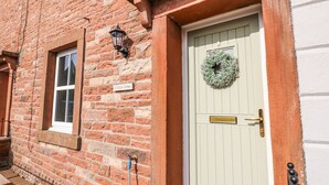 A brick building with a white door, a window, and a sign reading "3 Eden View".