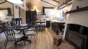 A modern kitchen with a dining area, a built-in oven, and a large mirror.