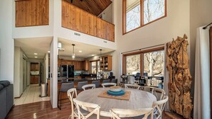 A spacious dining area with a round table, wooden chairs, and a view of the kitchen and living spaces. - Available Labor Day Wkd, Lake Front, Pickleball! (Garfield)