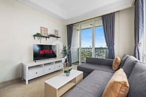 Relax in this stylish living room with a flat-screen TV, comfortable sofa, and city views.