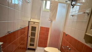 Un baño con inodoro, bañera y zona de ducha.