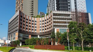A modern building with a curved facade, a prominent entrance, and a sign reading "SQUARE @ OKR".
