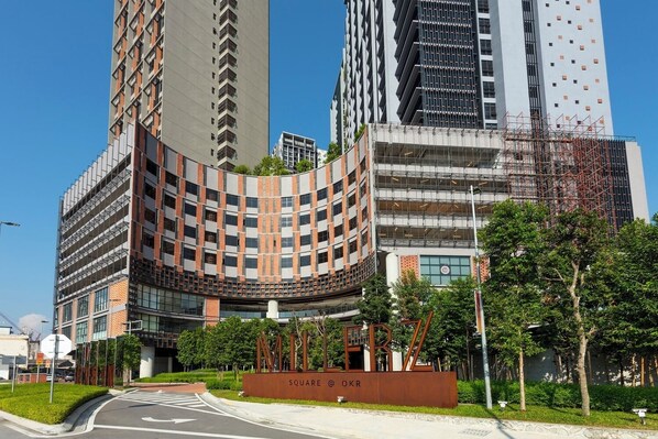 A modern building with a curved facade, a prominent entrance, and a sign reading "SQUARE @ OKR".