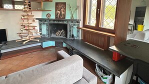 Un salon avec une cheminée, un canapé, une table à manger et une fenêtre donnant sur un beau paysage.