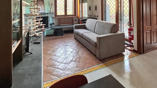 Un salon avec un canapé, une cheminée et une vue sur l’extérieur.