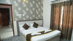 A hotel room with a large bed, a headboard, and a marble floor. - Sugandhi Bhoja Shetty (Mangaluru)