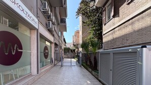 Un callejón urbano estrecho con una tienda llamada 'SKOLTAORA' y un edificio cerrado a la derecha.