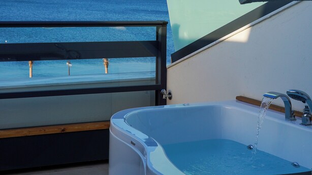 A balcony with a view of the sea, a bathtub, and a glass enclosure. - THE PİER OF URLA (Urla)