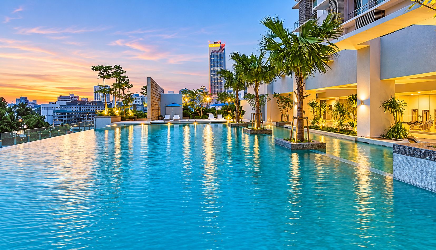A swimming pool with a cityscape in the background.