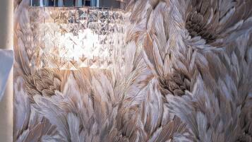 A modern room with a fluffy textured wall, a round table with a drawer, and a wall-mounted light fixture.