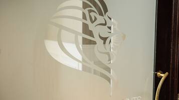 A glass door with the text "LEONE CAMERE D'AUTORE" and "PRINCE-ROOFTOP-EVENTS" along with a stylized lion's head design.
