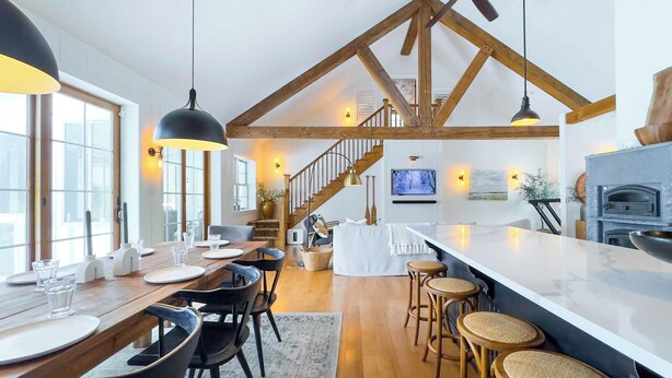 A spacious kitchen with a large island, wooden beams, and a stone oven. - Birch Beach Lake House-Hot tub/Sauna, Lake Access (Goderich)