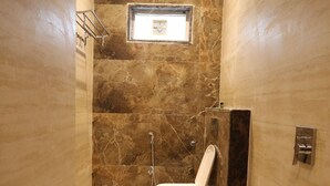 A small bathroom with a toilet, a shower, and a window. - RADHA BIHARI NIKUNJ INN & RESTAURANT (Vrindavan)