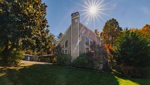 A house with a sloped roof, a chimney, and a well-maintained lawn. - Foxwood Retreat, just minutes from Harrah's Casino in downtown Cherokee (Whittier)