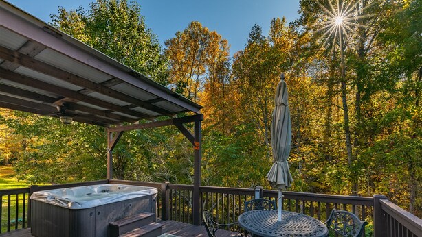 A hot tub on a wooden deck with a pergola, surrounded by trees and a view of the sky. - Foxwood Retreat, just minutes from Harrah's Casino in downtown Cherokee (Whittier)