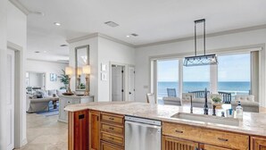 A spacious kitchen with a large island, a dishwasher, and a view of the ocean. - Sea Haven - Oceanfront home w/beach access & deck (Ponte Vedra Beach)