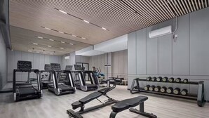 A modern gym with treadmills, a bench press, and dumbbells. - MEHOOD LESTIE Hotel Guangzhou Tianhe Financial City (Guangzhou)