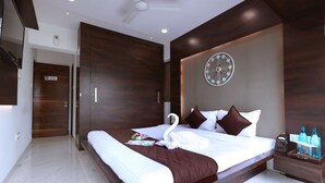 A modern hotel room with a large bed, a wall clock, and a minibar. - 3 Bedroom Apartment ( Gagal Home) (Mumbai)