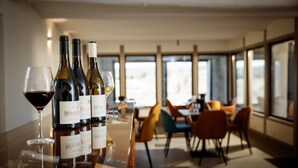 A bar area with wine bottles and glasses, large windows, and modern furniture. - Gîte Cévennes 2*, Pic Saint Loup (Vacquières)