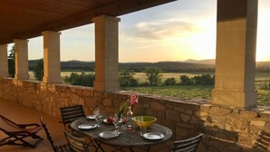 An outdoor dining area with a table set for two, stone walls, and a view of the countryside. - Gîte Cévennes 2*, Pic Saint Loup (Vacquières)