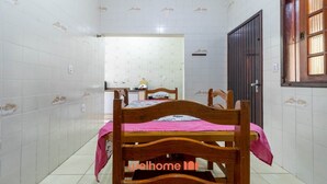 A bedroom with a wooden bed, a small desk, and a window. - Casa em Praia Grande bem localizada a 300m do mar (Praia Grande)