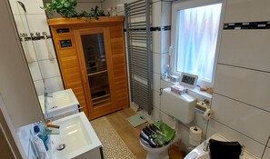 A bathroom with a toilet, sink, shower, and a window with a view. - Sunny room 2 with own living room, bathroom, terrace (Dürrwangen)