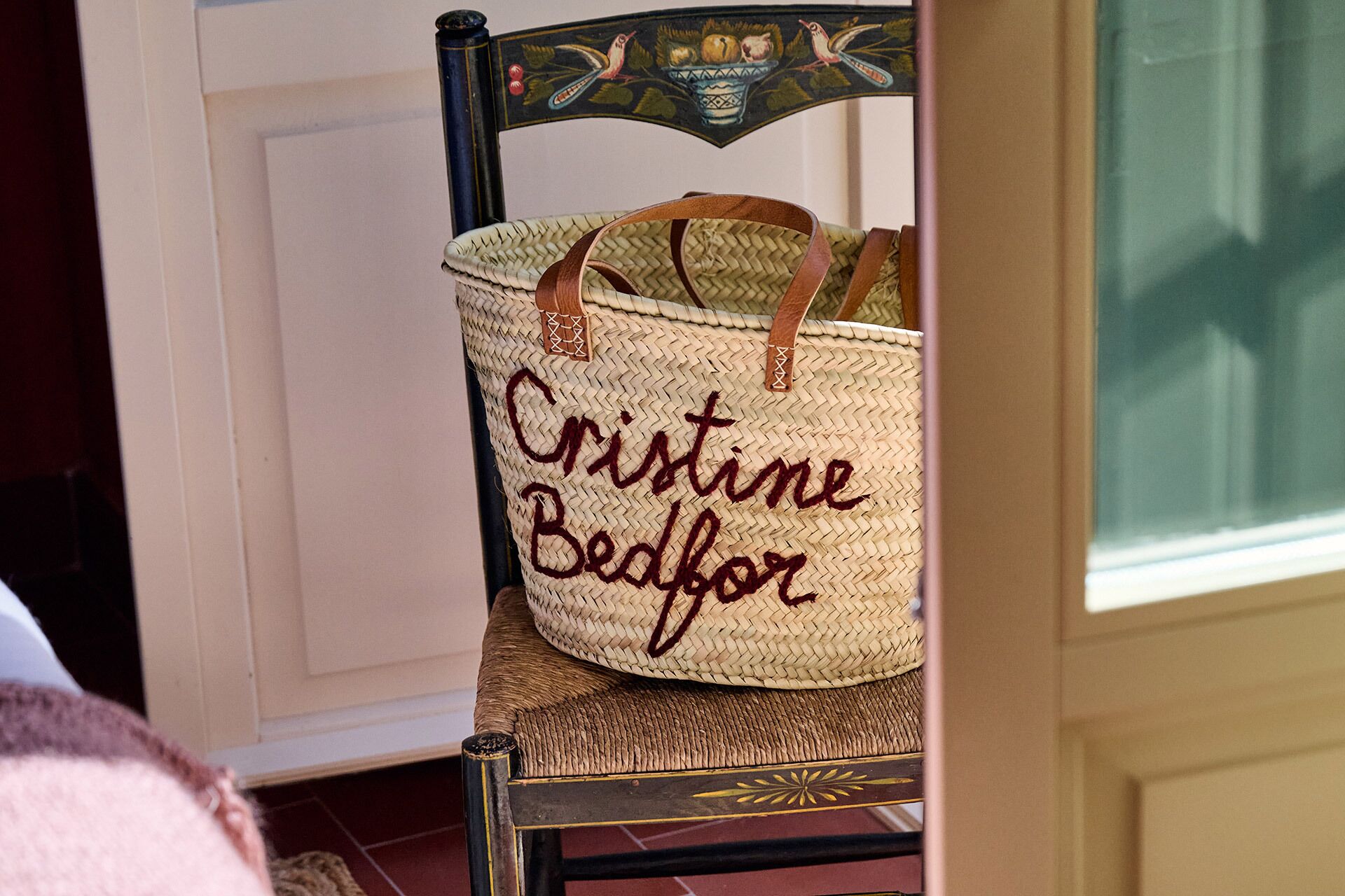 A woven basket with handles on a chair.