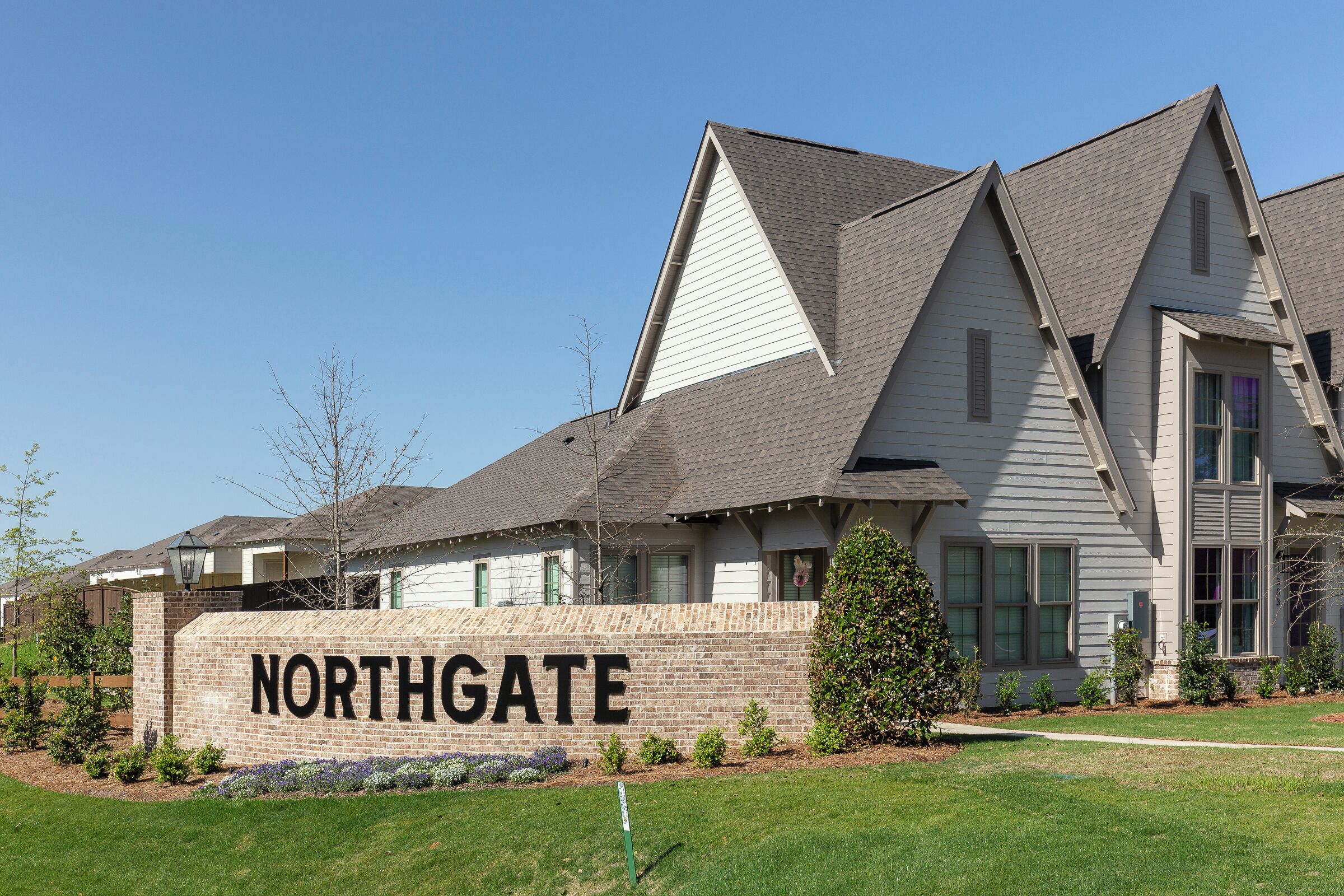 En boligbygning med et skilt der siger "NORTHGATE" og en velholdt græsplæne.