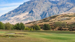 A golf course with a mountain backdrop.