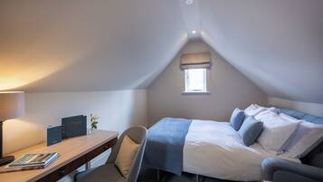 Une chambre à coucher avec un lit, un bureau, une chaise, une fenêtre et une lampe.