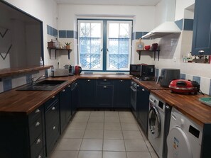 A compact kitchen with a sink, stove, microwave, and a washing machine.
