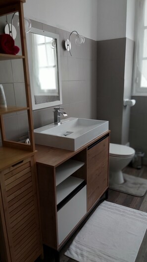 A modern bathroom with a white sink, wooden vanity, and a mirror. - Family-friendly vacation rental in the heart of Saint-Aignan – ideal 3-night stay – 5 min from Beauval Zoo (Saint-Aignan)